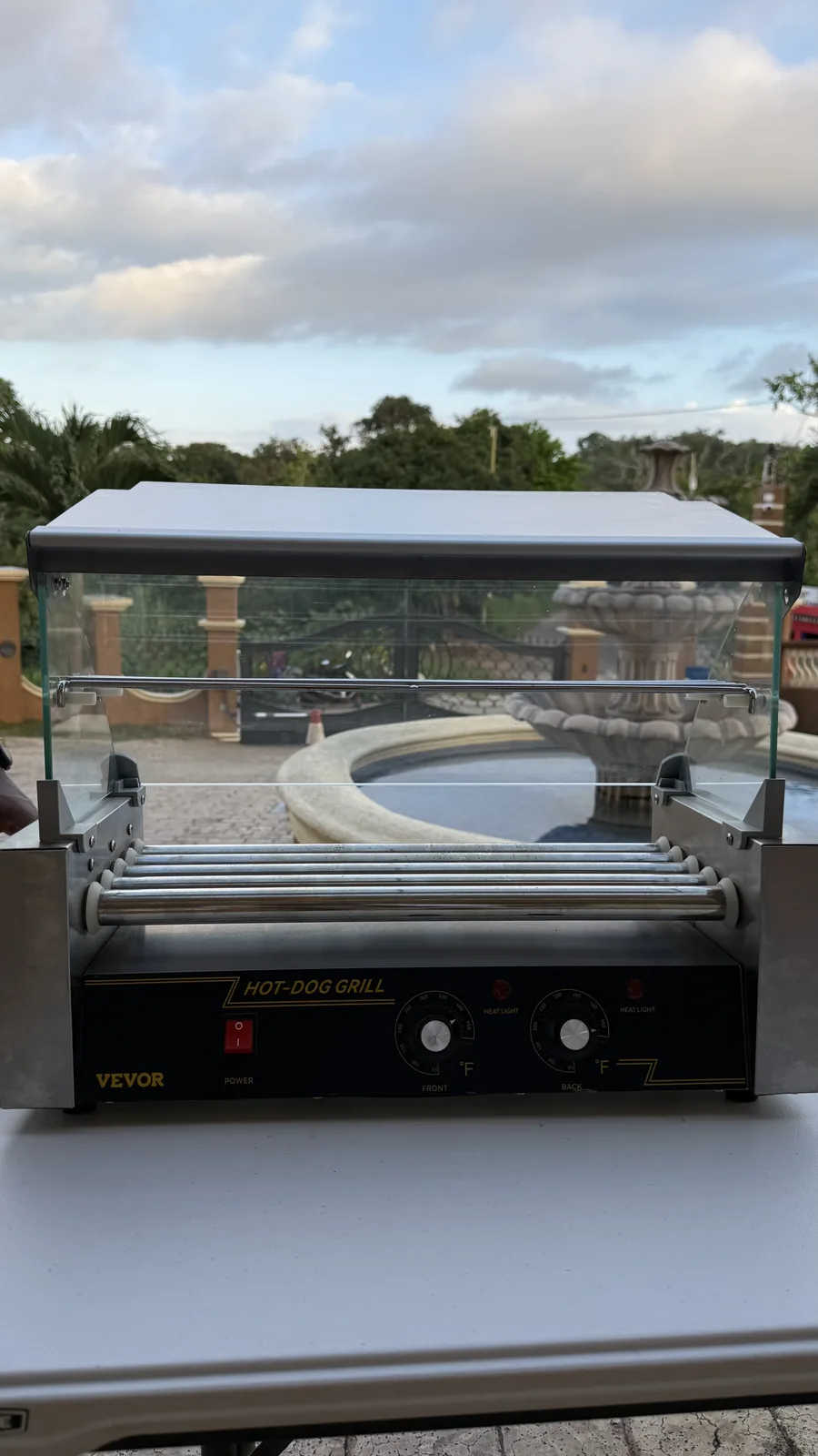 Front view of the hot-dog grill showing the rollers and controls