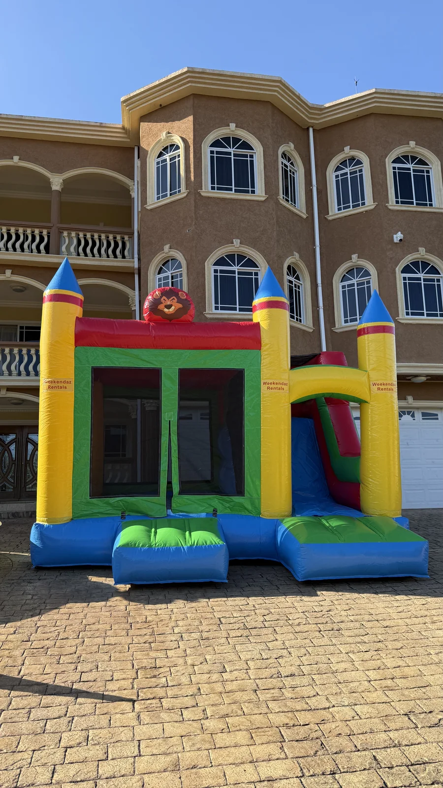 Front view of the Weekendaz 15 by 15 foot bouncer with attached slide