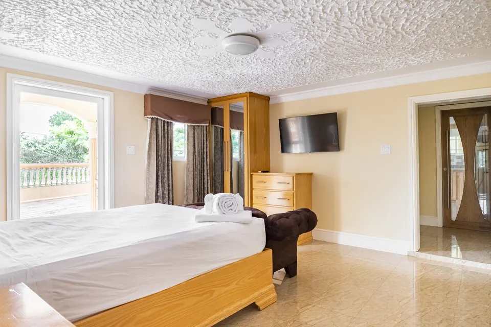 Room 1 ( second of the two rooms on the ground floor). This room consists of a standing fan along with an AC Unit, a 42" Samsung Smart tv, a patio, an en suite bathroom as well as a private entrance.