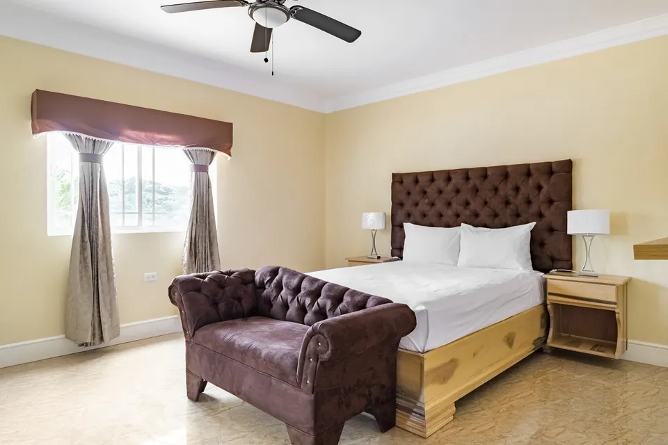 Room 4 ( Second of the three rooms on the first floor). This room consists of an AC unit, a ceiling fan, a 42" Samsung Smart tv with a nice view of the pool area, as well as an en suite bathroom.