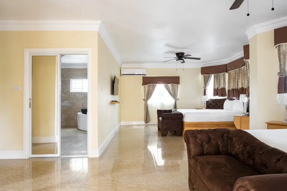 Room 5 ( Third of the 3 rooms on the first floor). This room consists of two ceiling fans along with an AC Unit, a 42" Samsung Smart tv, a patio, an en suite bathroom with a jacuzzi.